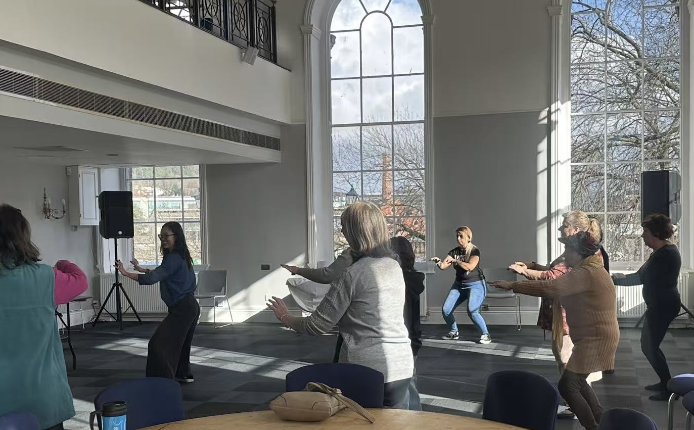 Dr Jar leading an active Tai Chi session in a bright community hall